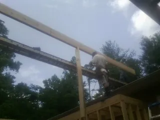 Carpenter setting a ridge beam over a new addition frame — Ice Dam Removal by Roofing Brothers in Haw River