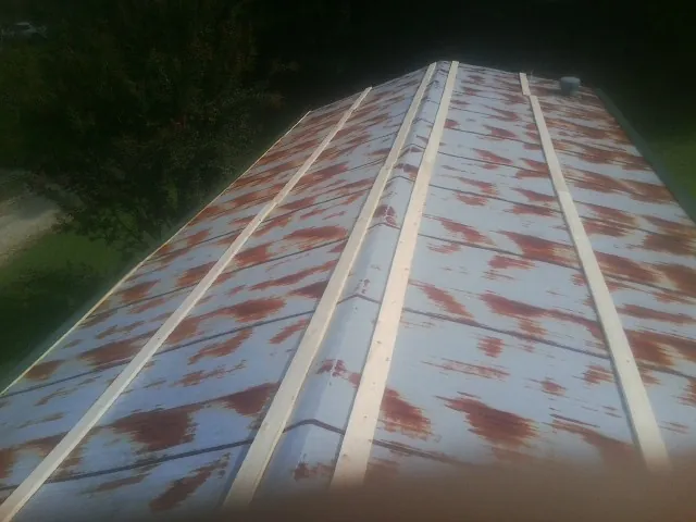 Rusted metal roof panels with new wood purlins before replacement — Storm Damage Roof Repair in Haw River by Roofing Brothers