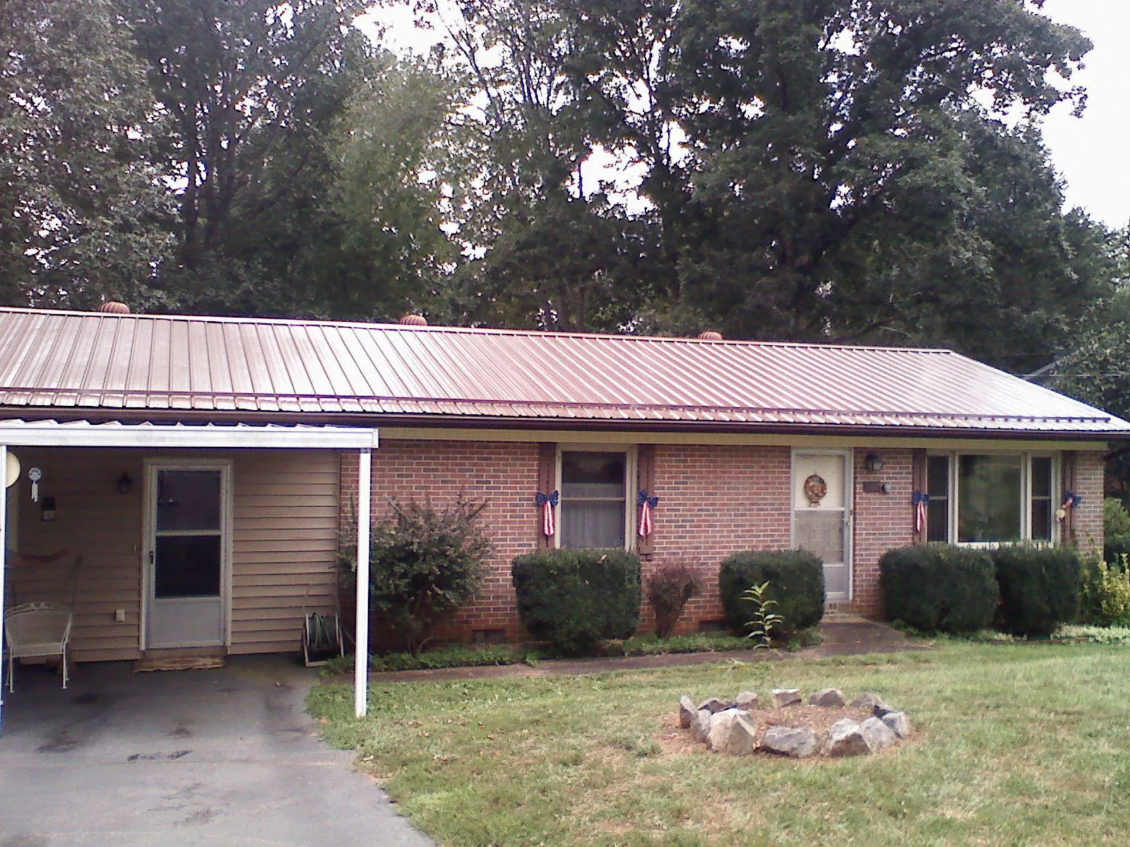 Bronze metal roof and carport on a brick ranch home — Roof Repair work by our crew in Haw River