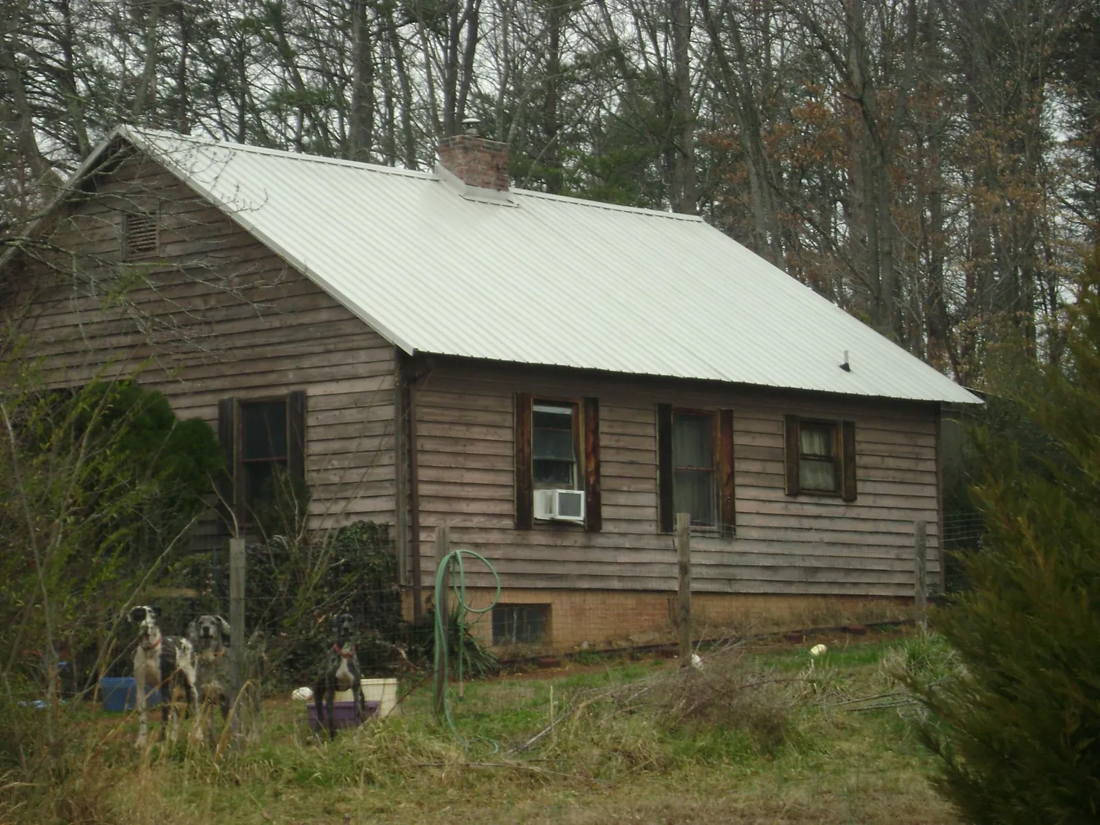 White metal roof on an old wood sided farmhouse, from a Metal Roof Installation job in Haw River